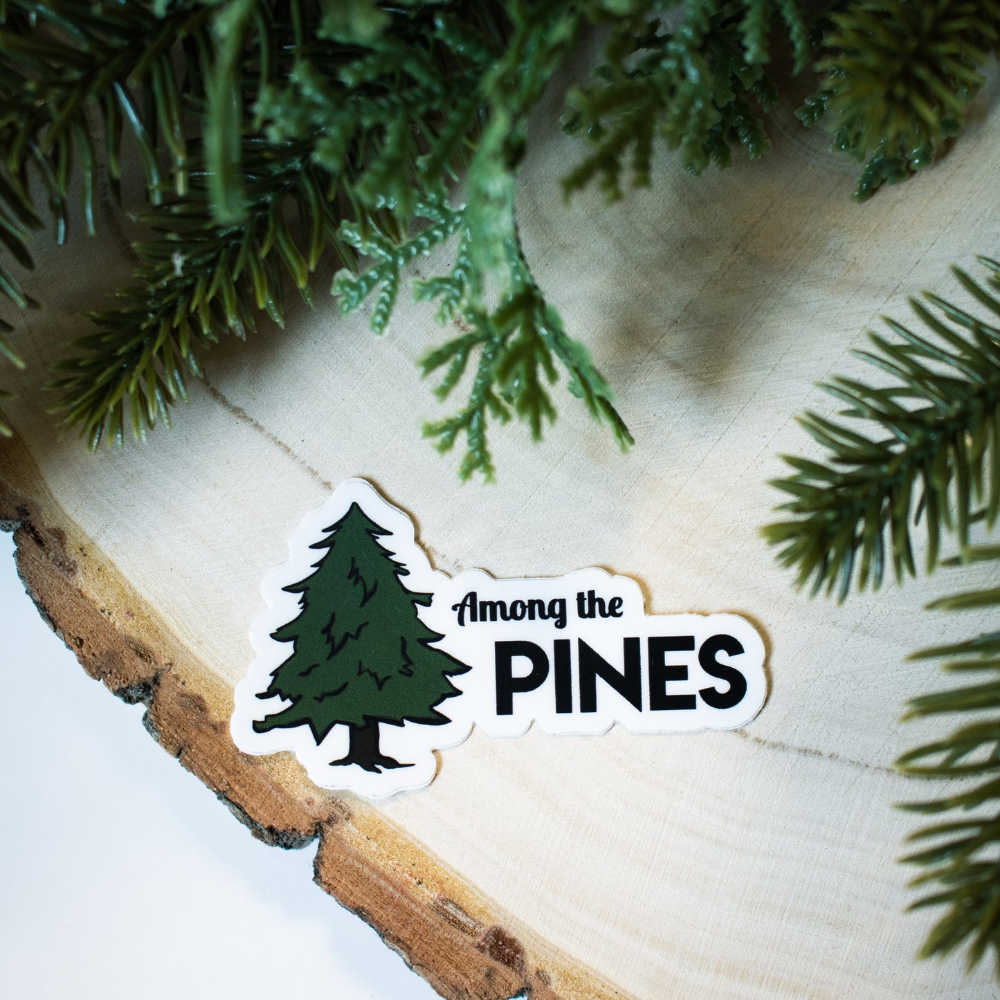 black outlined pine tree illustration with combination of script and bold solid fonts
